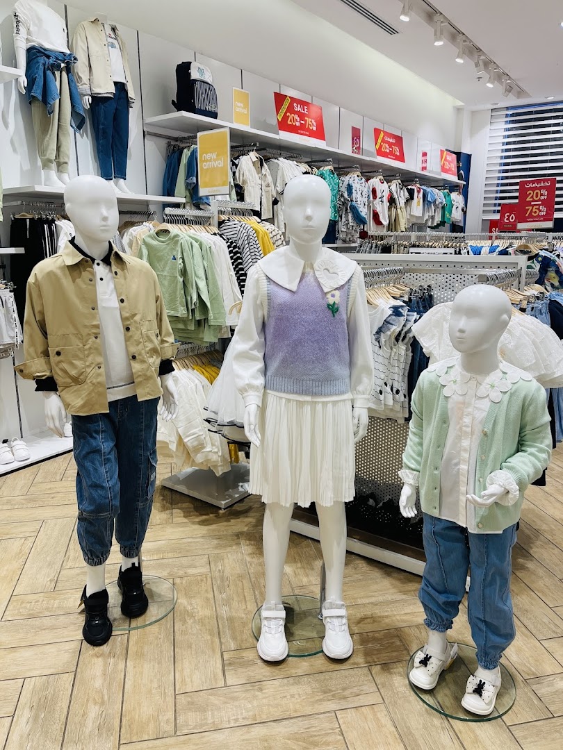 Mannequins display children's clothing, featuring new arrivals and sale items.