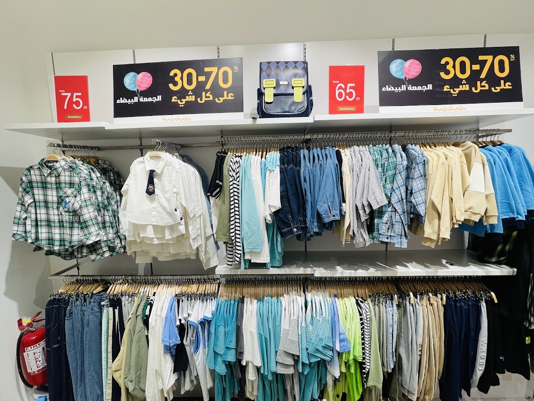 A retail shop display featuring a wide selection of clothing on racks, with sale signs.