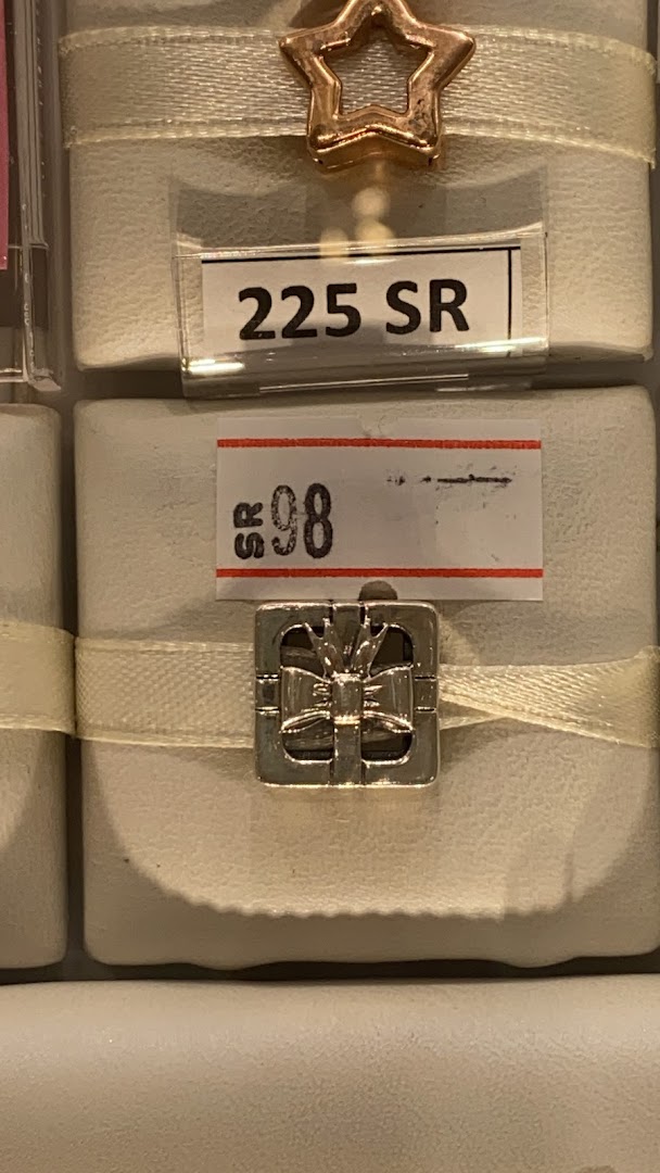 Close-up of Pandora charms with price tags, one shaped like a gift box.