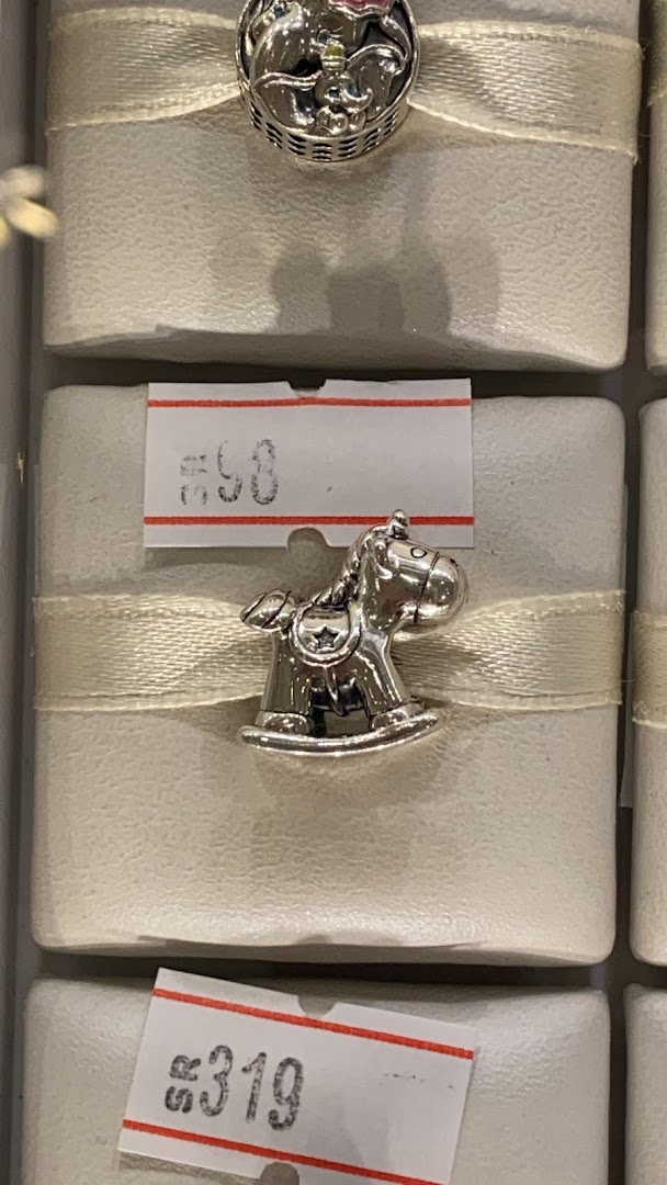 Close-up of Pandora charms, including a rocking horse and a basket-themed charm.