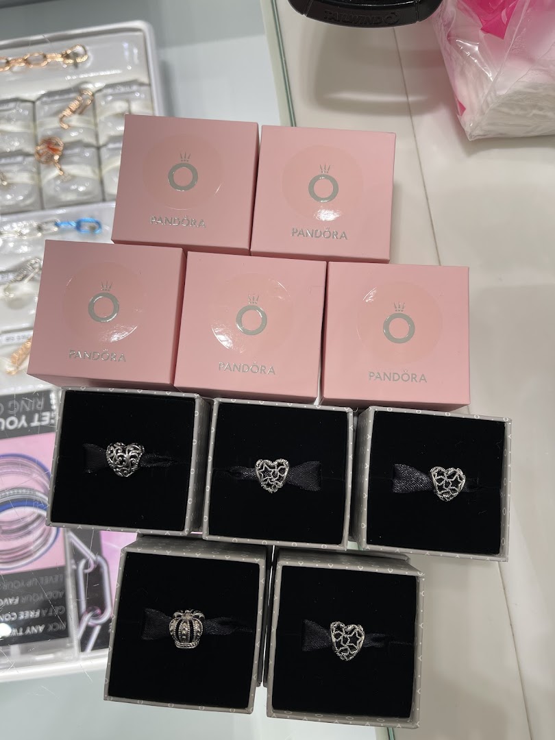 Pandora jewelry charms displayed in their signature pink boxes and individual gift boxes.