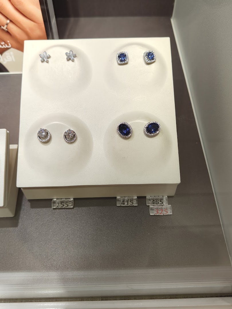 A display of Pandora earrings featuring butterfly, square blue, round clear, and oval blue designs.