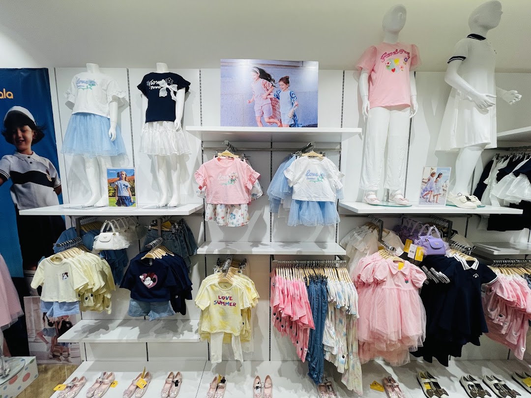 A well-organized display of children's clothing and accessories, featuring mannequins and racks of apparel.