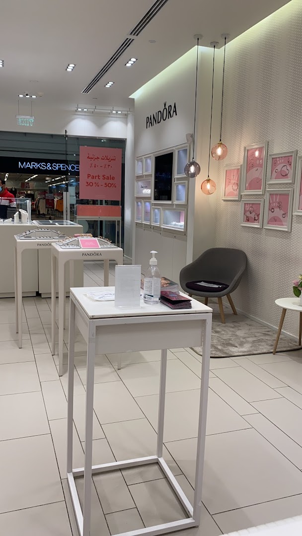 Interior view of a Pandora jewelry store with display cases and a sale banner.