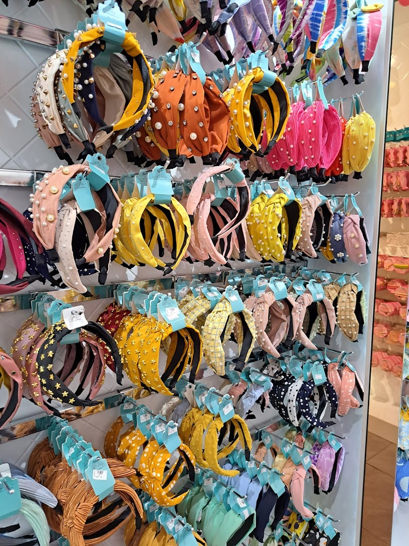 A vibrant display of colorful headbands adorned with pearls, studs, and various patterns.