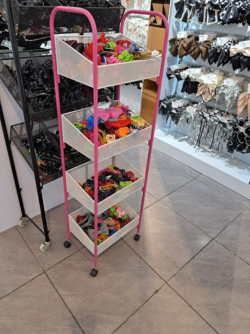 A display rack filled with colorful hair clips and accessories, with more items on shelves in the background.