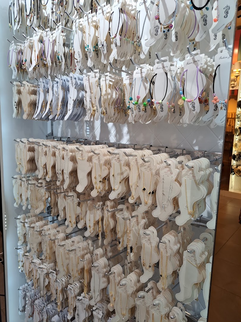 A wall display showcasing a wide variety of necklaces and anklets.