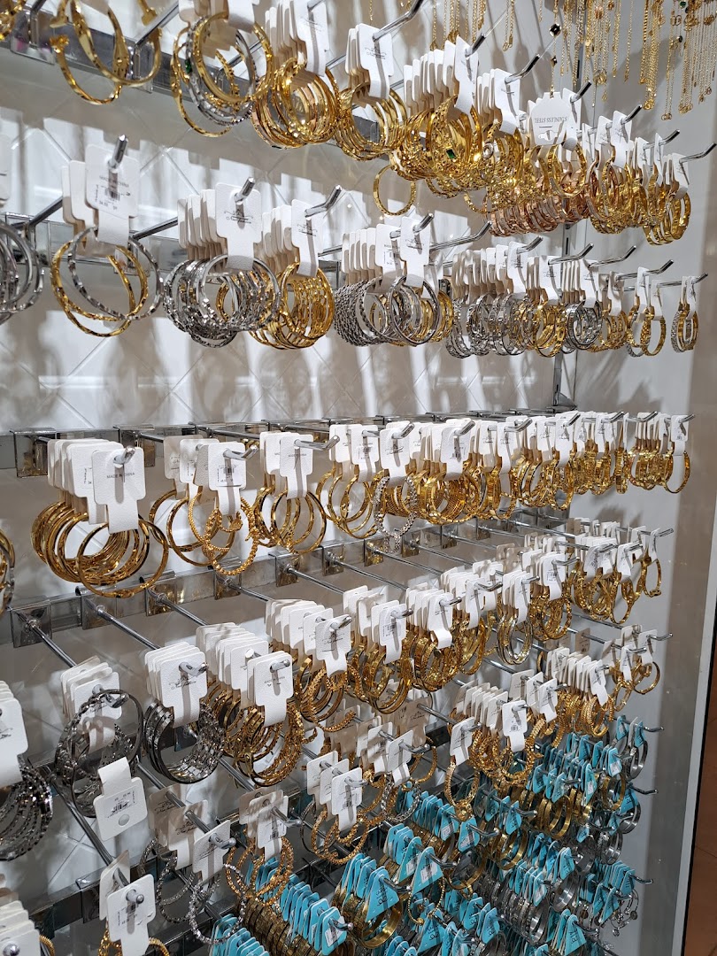 A wall display showcasing a wide variety of gold and silver hoop earrings.