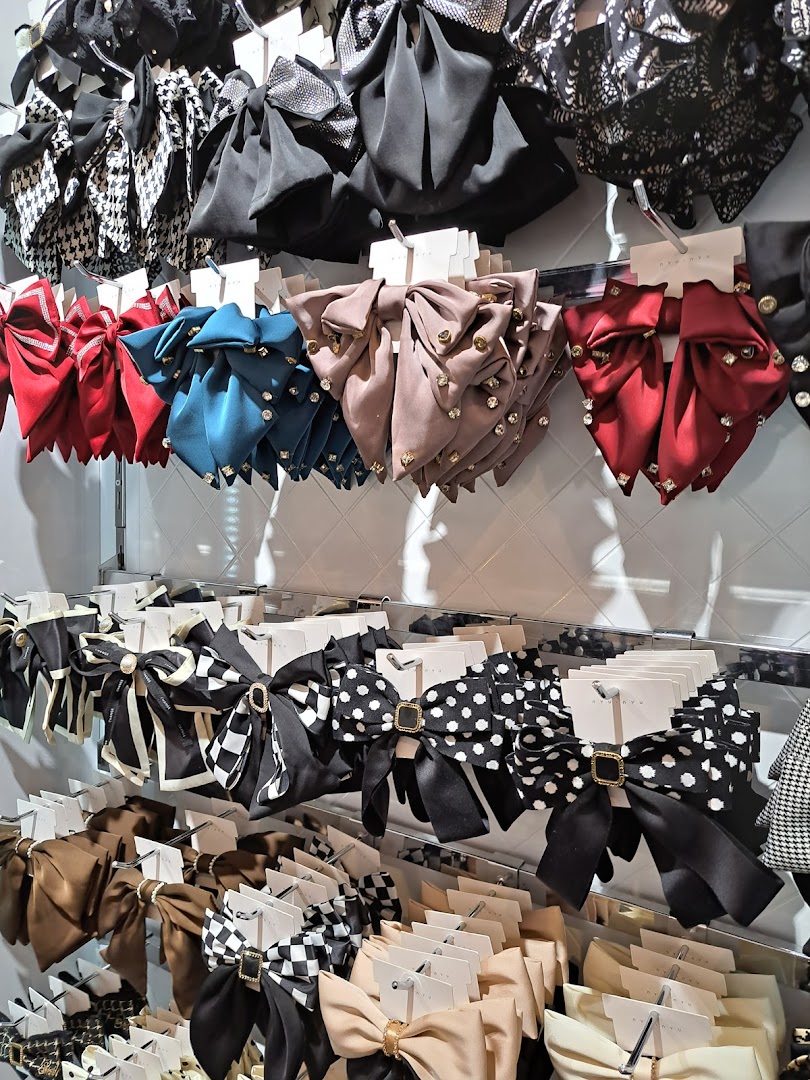 A display of various bow hair accessories in different colors and patterns.