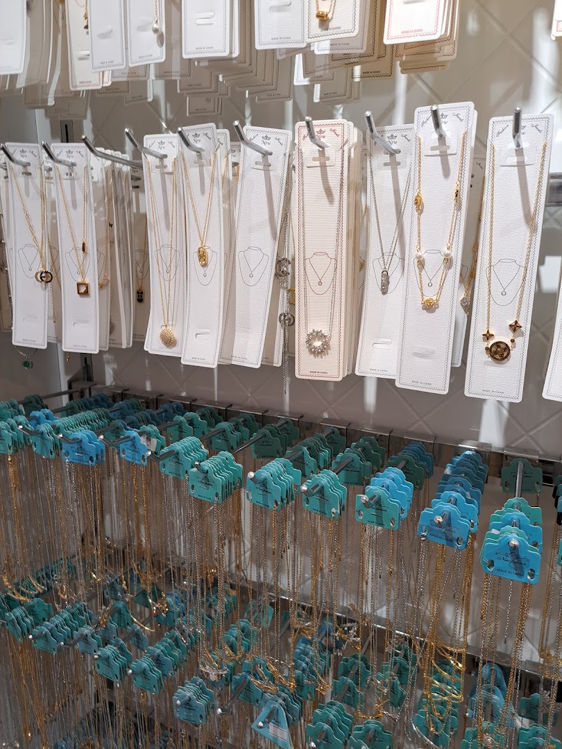 A display of necklaces with various pendants, neatly arranged on racks.