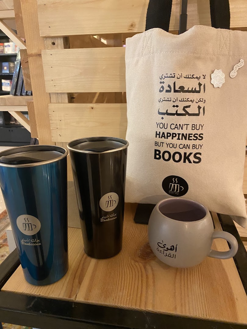 Bookccino branded merchandise including tumblers, a tote bag, and a mug.