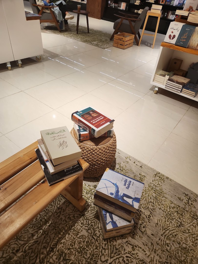 Cozy bookshop interior with comfortable seating and stacks of books on display.