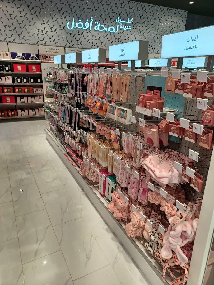 A well-lit retail store aisle showcasing a variety of beauty and personal care products, including makeup and hair accessories.