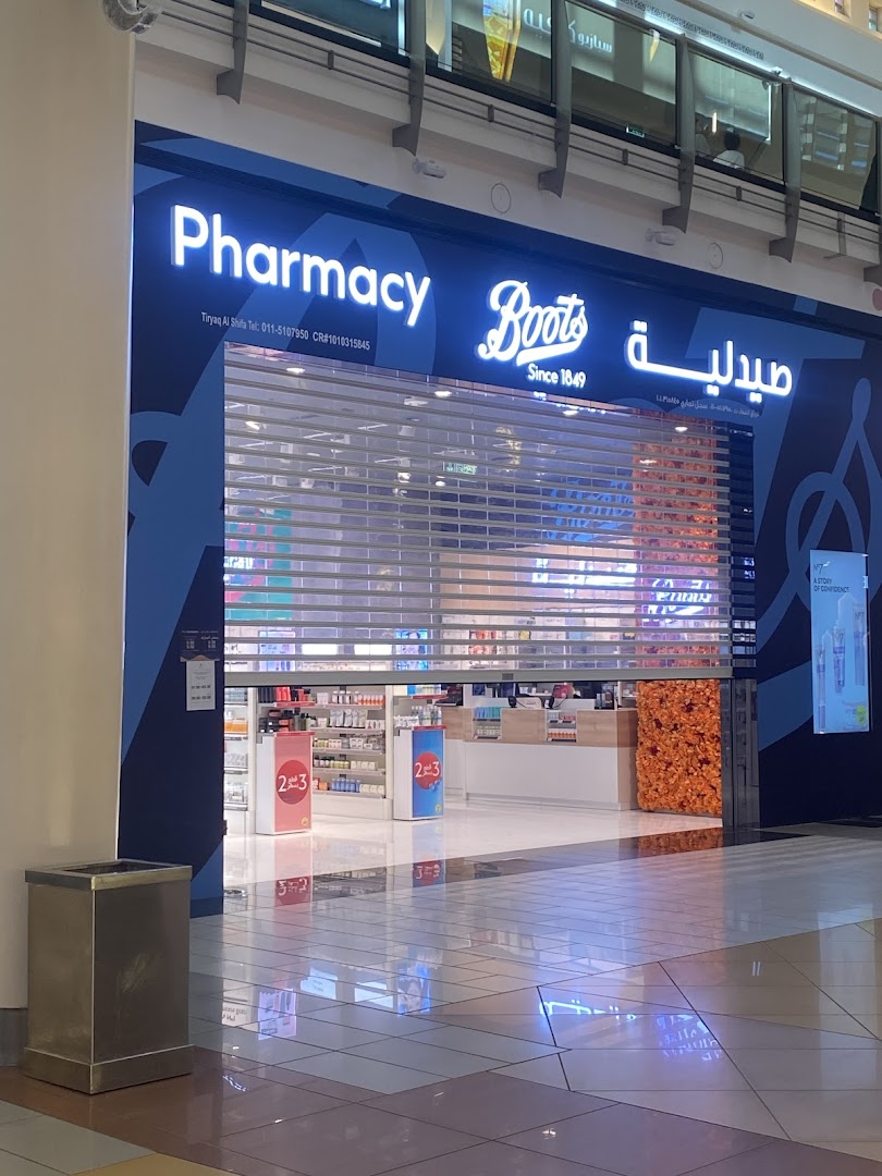 The exterior of a Boots pharmacy with its signage and a closed roller shutter.
