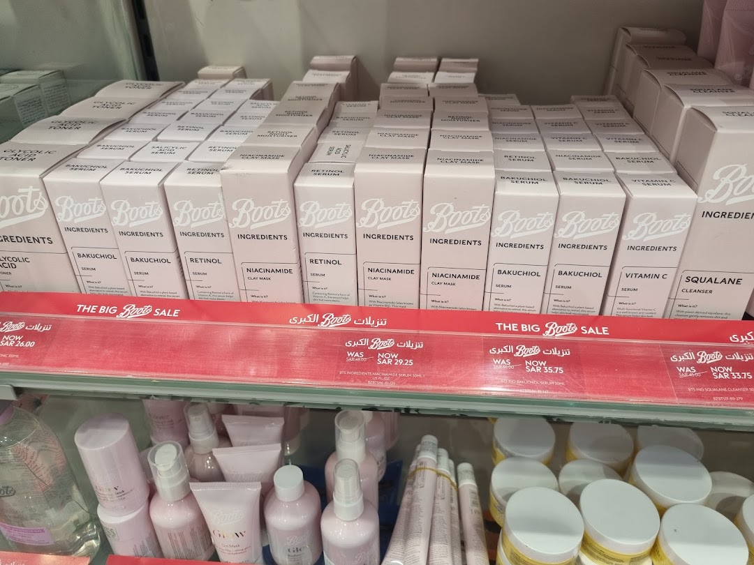 Shelves stocked with Boots skincare products, featuring serums and cleansers, with sale signage.