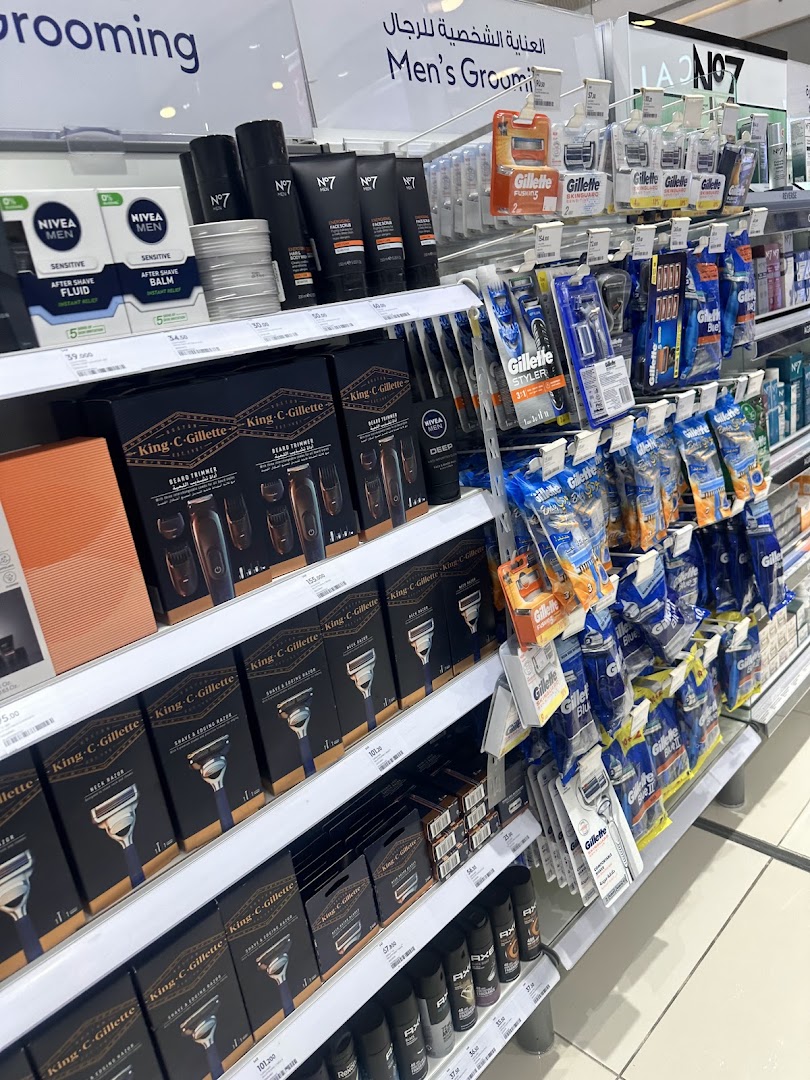 Shelves stocked with men's grooming products including razors, shaving creams, and aftershave.