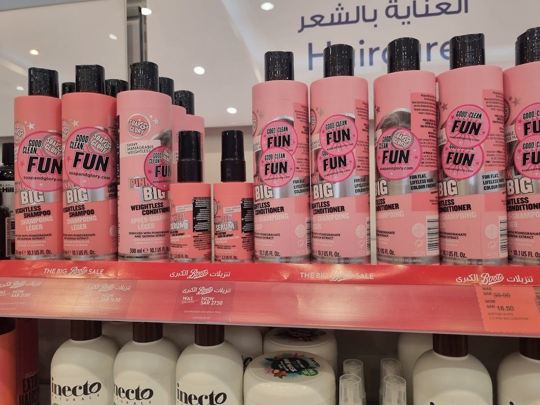 Shelves stocked with pink bottles of Soap & Glory hair products, including shampoos and conditioners.