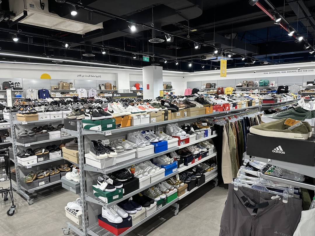 Interior view of a retail store showcasing a wide selection of shoes and apparel on display shelves.