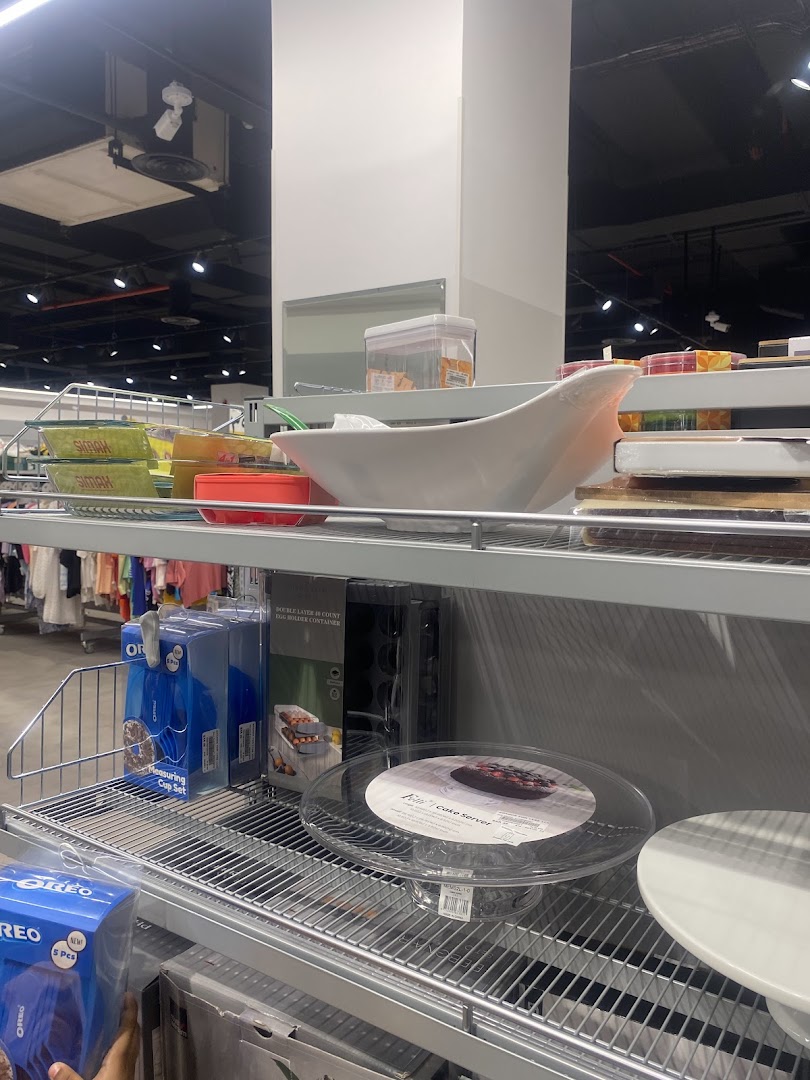 Shelves stocked with kitchenware, including cake servers, measuring cups, and storage containers.