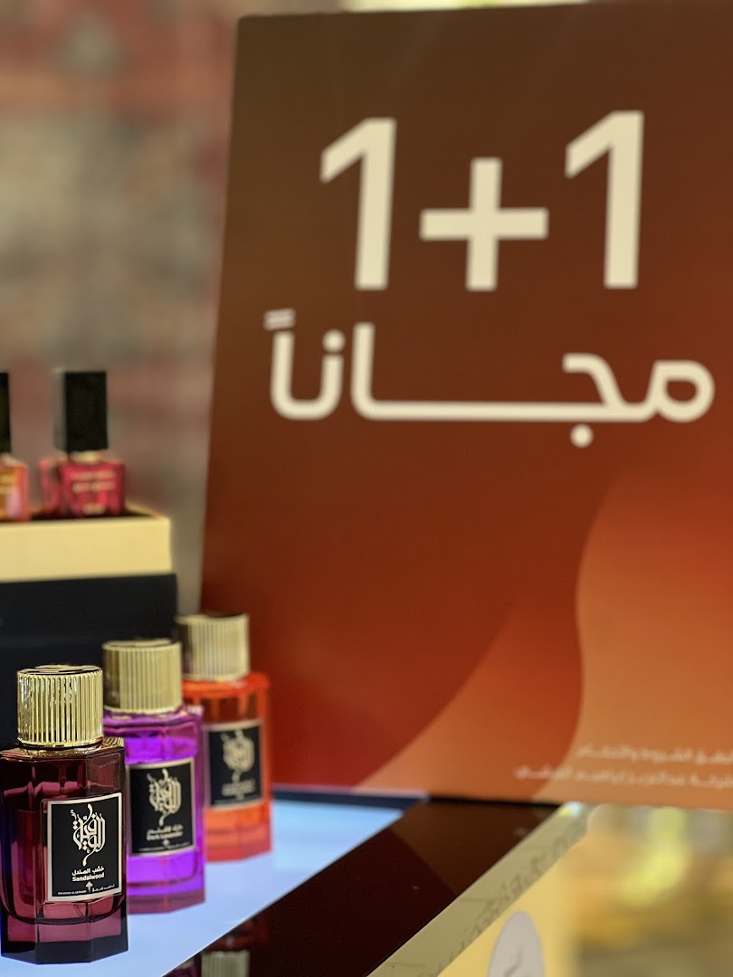 Perfume bottles displayed with a "1+1 Free" offer sign in the background.
