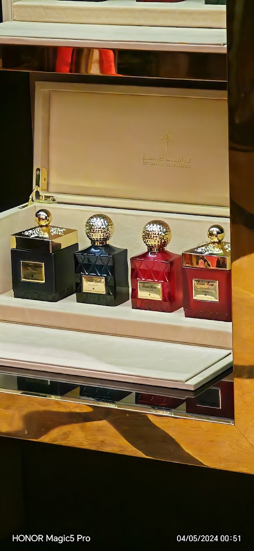 A display of four elegant perfume bottles from Ibrahim AlQurashi, presented in a luxurious box.