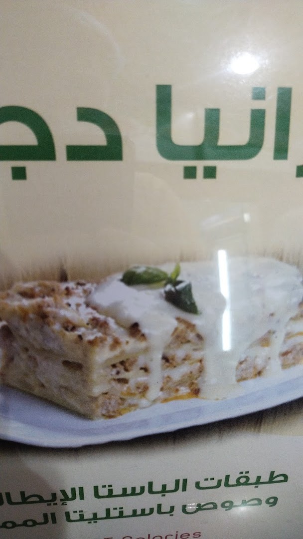 A close-up of a delicious-looking lasagna dish with creamy sauce and basil.