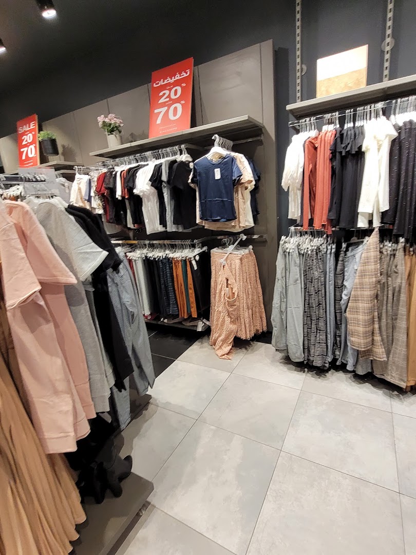 Interior view of a Calliope clothing store with racks of apparel and sale signs.