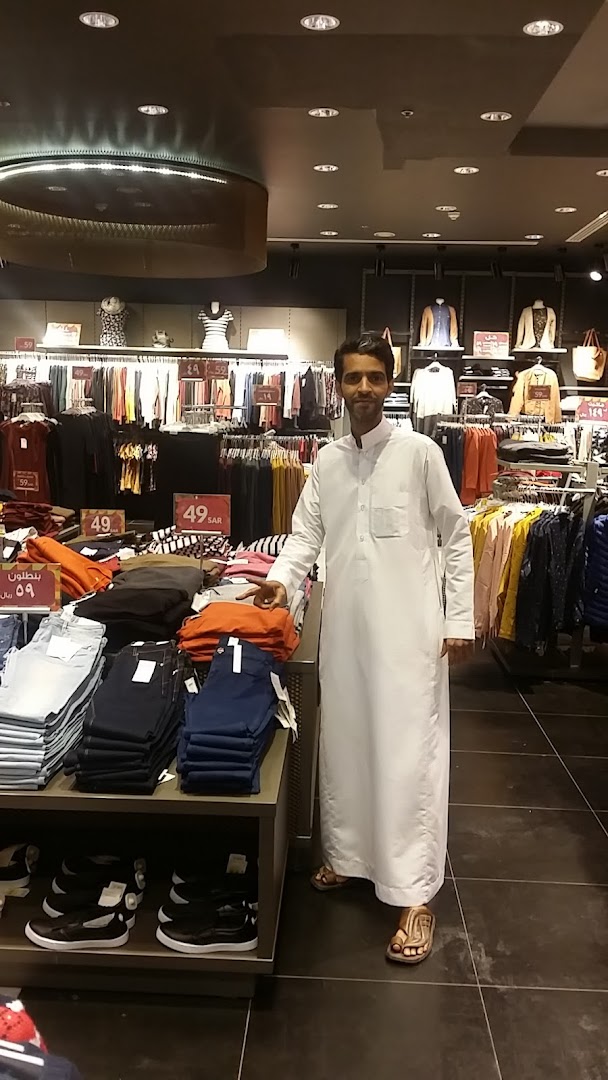 A man stands in a Calliope clothing store, surrounded by racks of apparel and display tables.