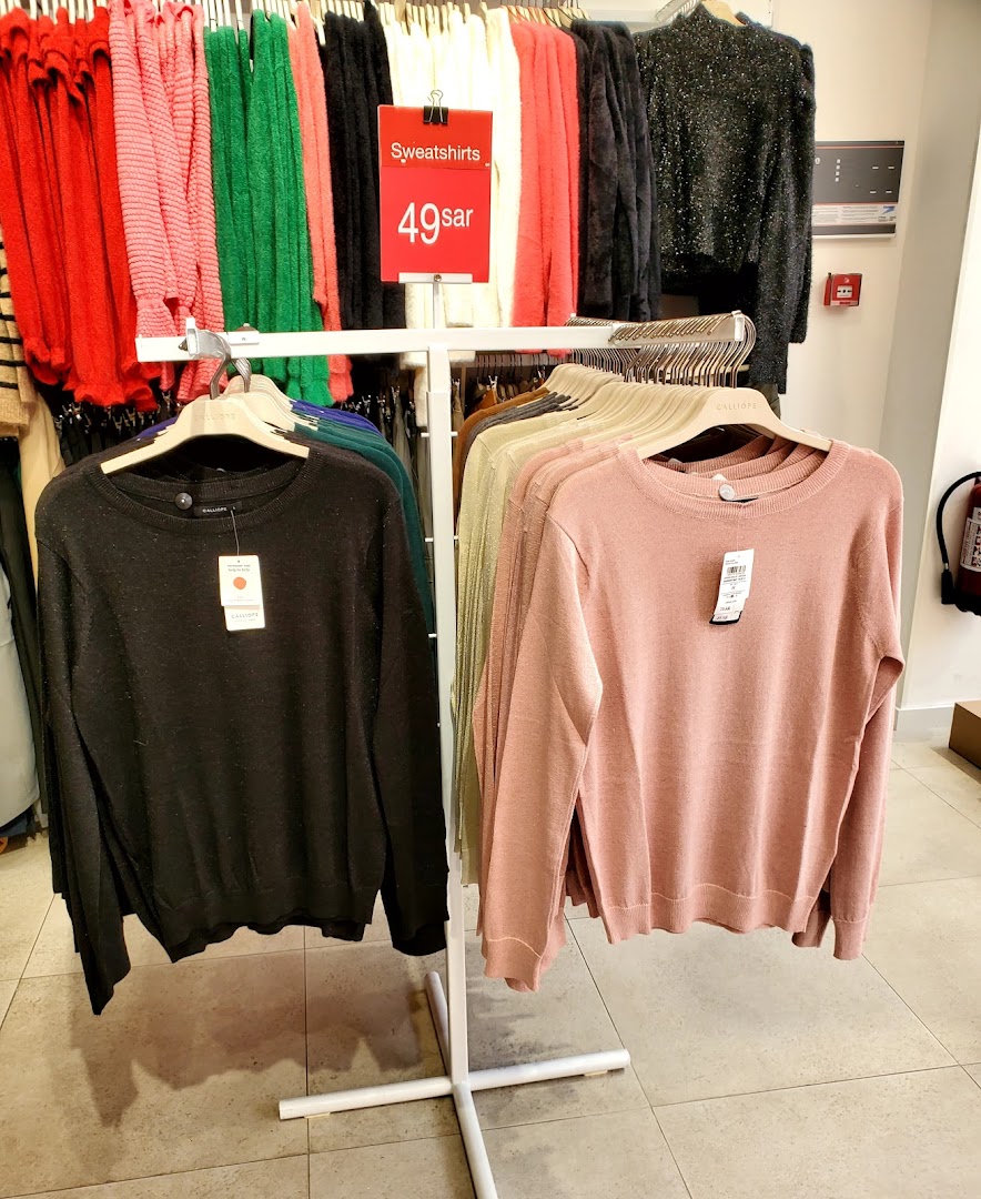 A display of colorful sweatshirts and sweaters for sale at Calliope.
