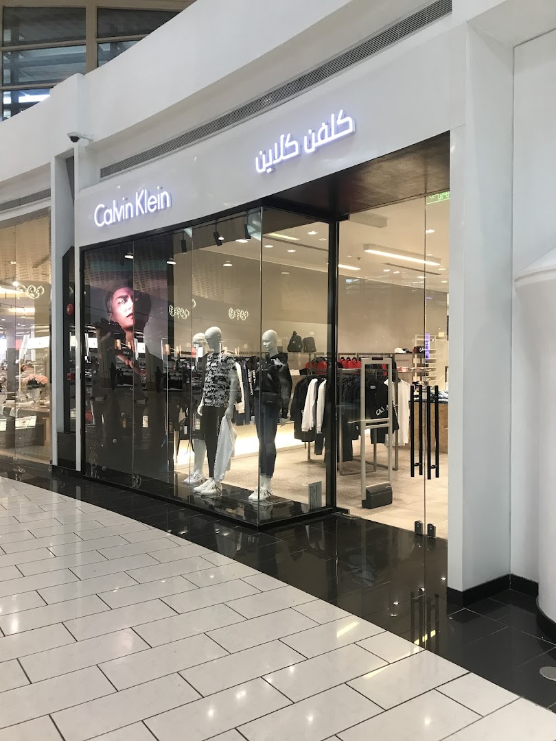 The Calvin Klein store features a modern storefront with mannequins displaying clothing and the brand's logo.
