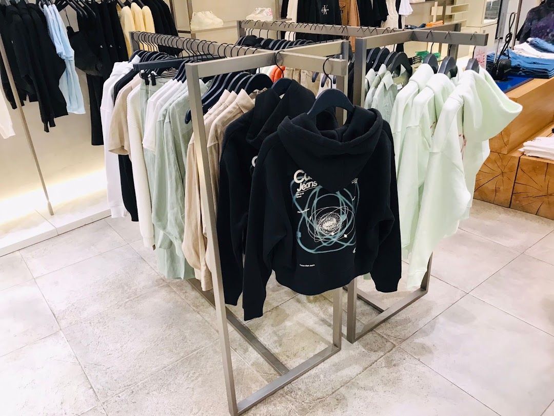 A display of Calvin Klein hoodies and apparel on racks inside a store.