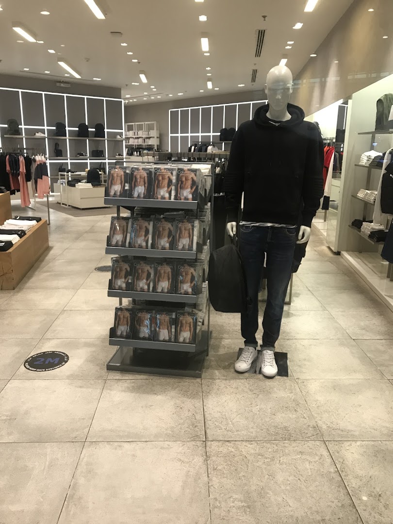 Interior of a Calvin Klein store with a mannequin and displays of underwear.