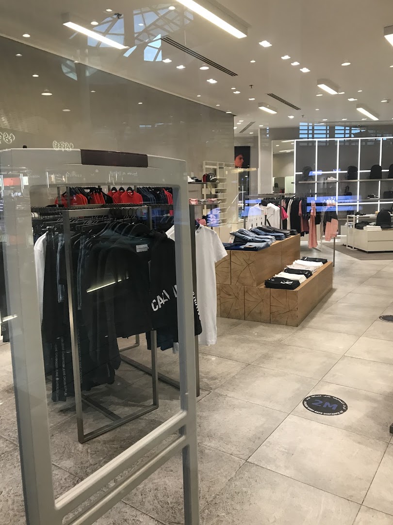 Interior view of a Calvin Klein store showcasing clothing displays and merchandise.