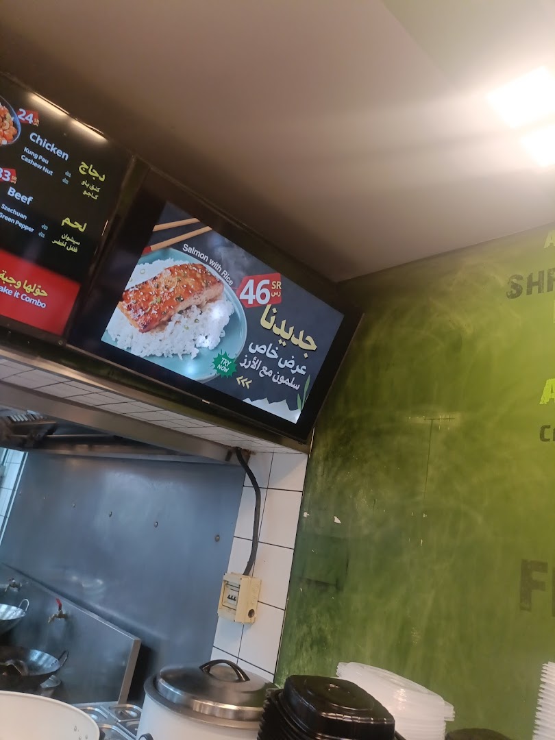 A digital menu board displays food items including chicken, beef, and salmon with rice.