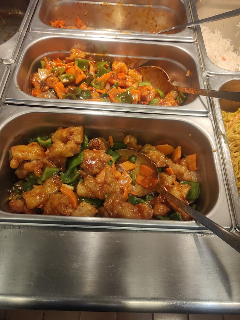 A close-up of three buffet trays filled with various Asian dishes, including stir-fried chicken and vegetables.