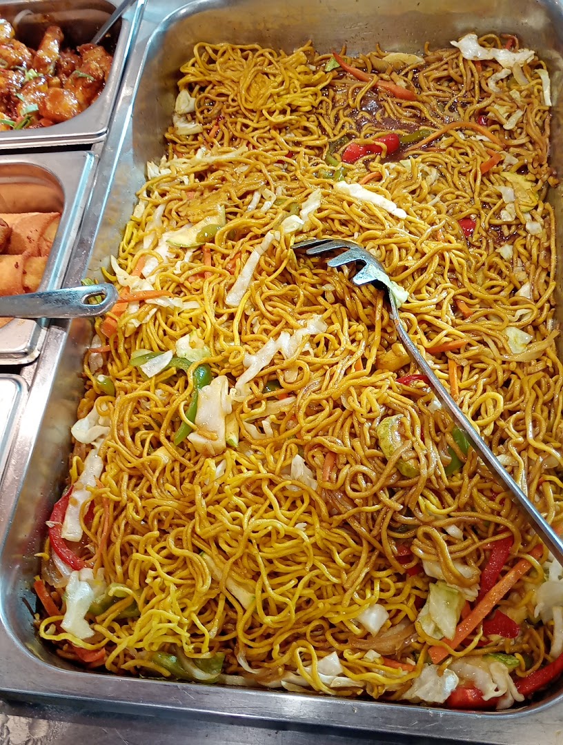A close-up of a large tray filled with delicious-looking stir-fried noodles and vegetables.