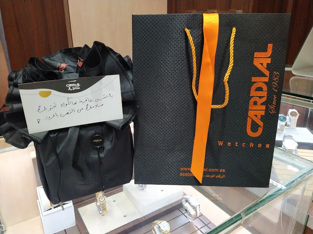 A Cardial branded shopping bag and a gift bag with a handwritten note, displayed with watches.