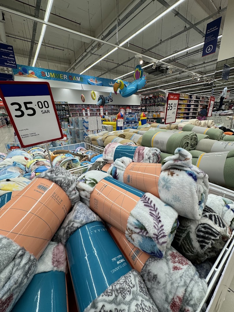 A display of rolled-up soft flannel blankets with price tags in a retail store.
