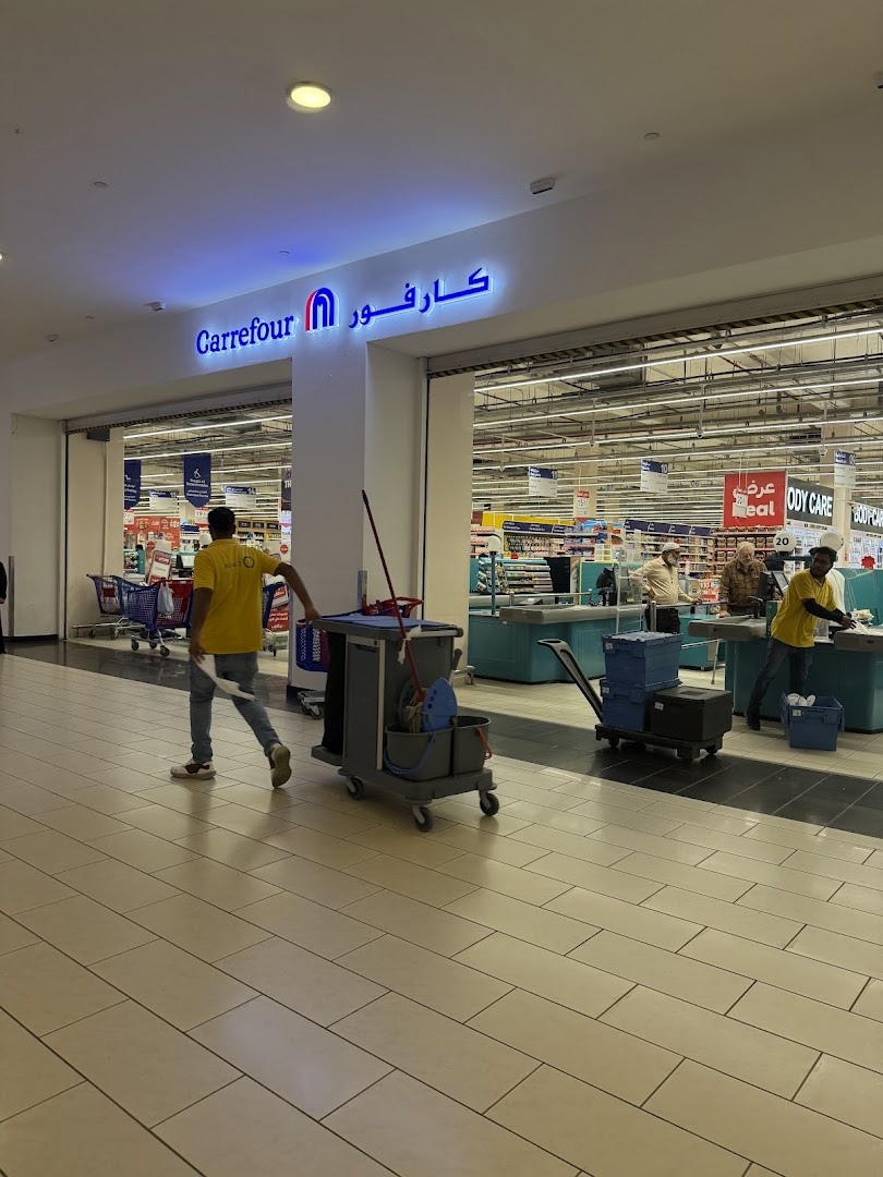 The entrance of Carrefour Granada Hypermarket with staff and shopping carts visible inside.
