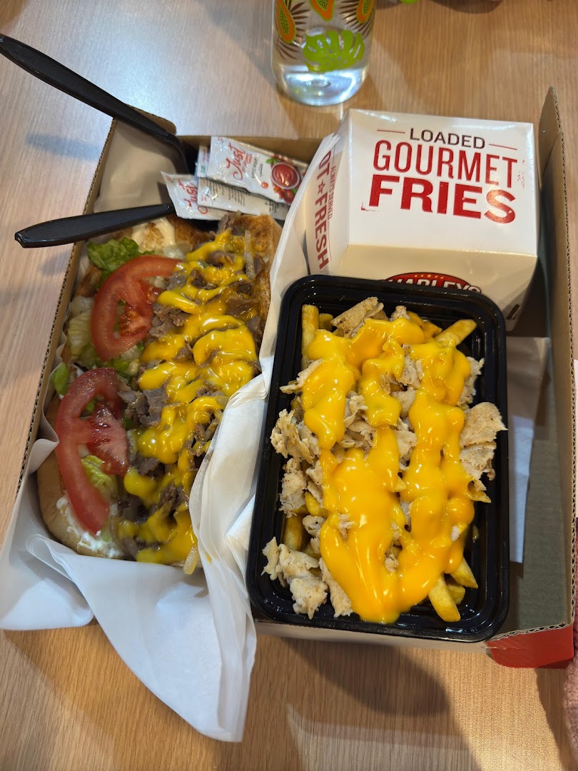 A delicious Charleys Cheesesteaks meal featuring a loaded cheesesteak and gourmet fries.