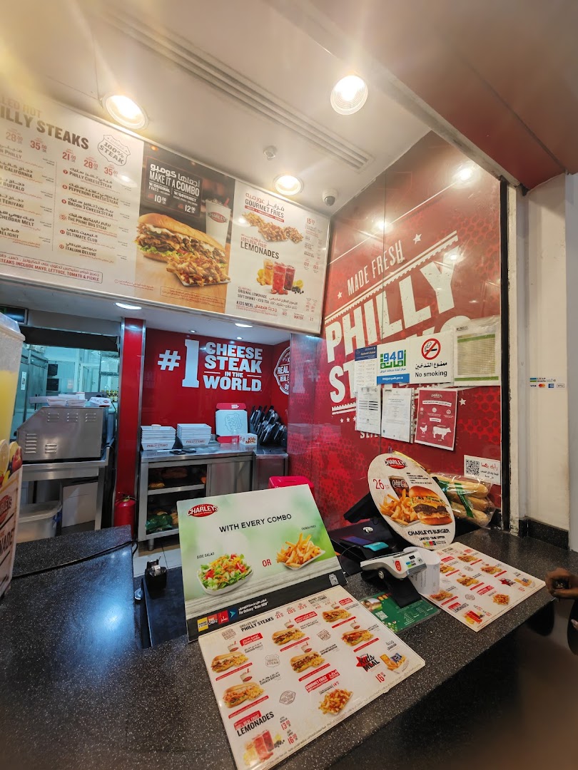 Interior view of a Charleys Cheesesteaks counter with menus and food displays.