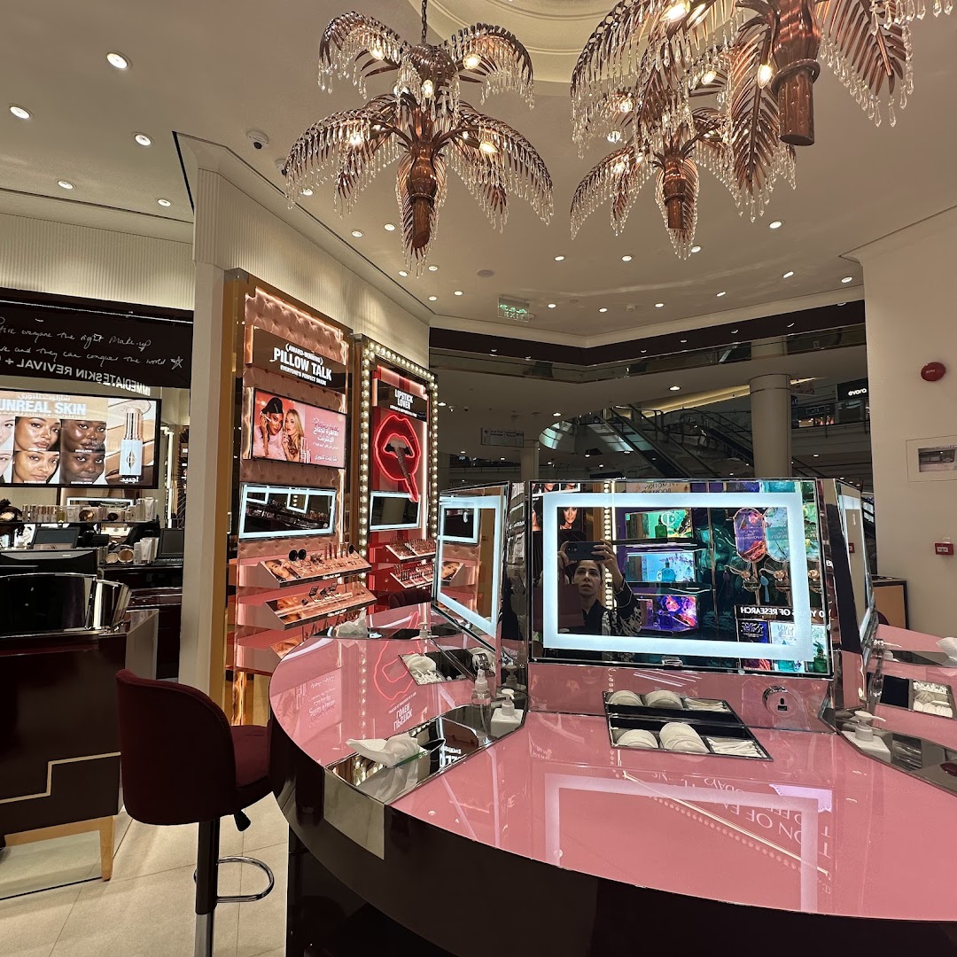 Interior of a Charlotte Tilbury beauty store with makeup displays and illuminated mirrors.