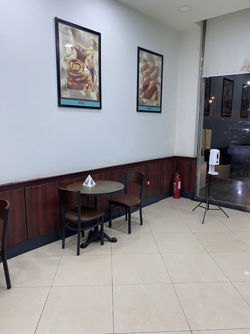 Interior seating area with framed pictures of cinnamon rolls and croissants.