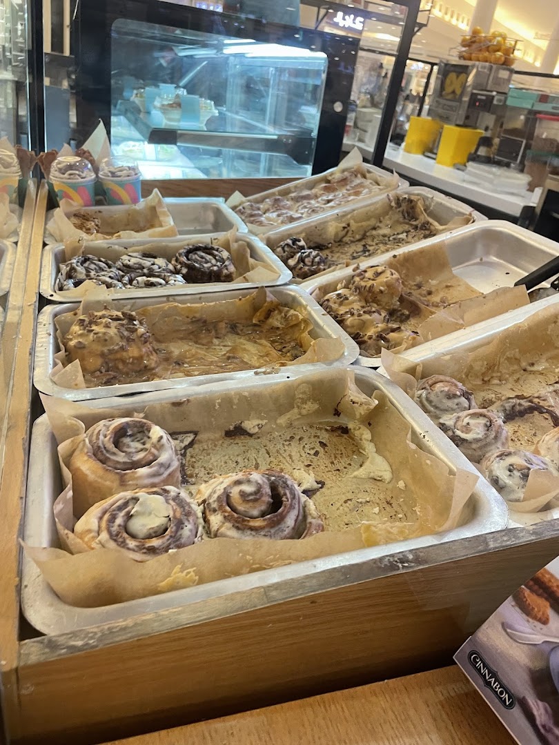 A display of freshly baked cinnamon rolls with various toppings and frosting.