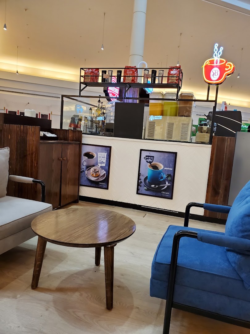A cozy seating area with a coffee counter and promotional posters.