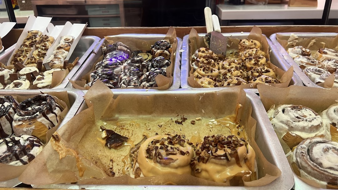 A display of various Cinnabon cinnamon rolls with different toppings and drizzles.