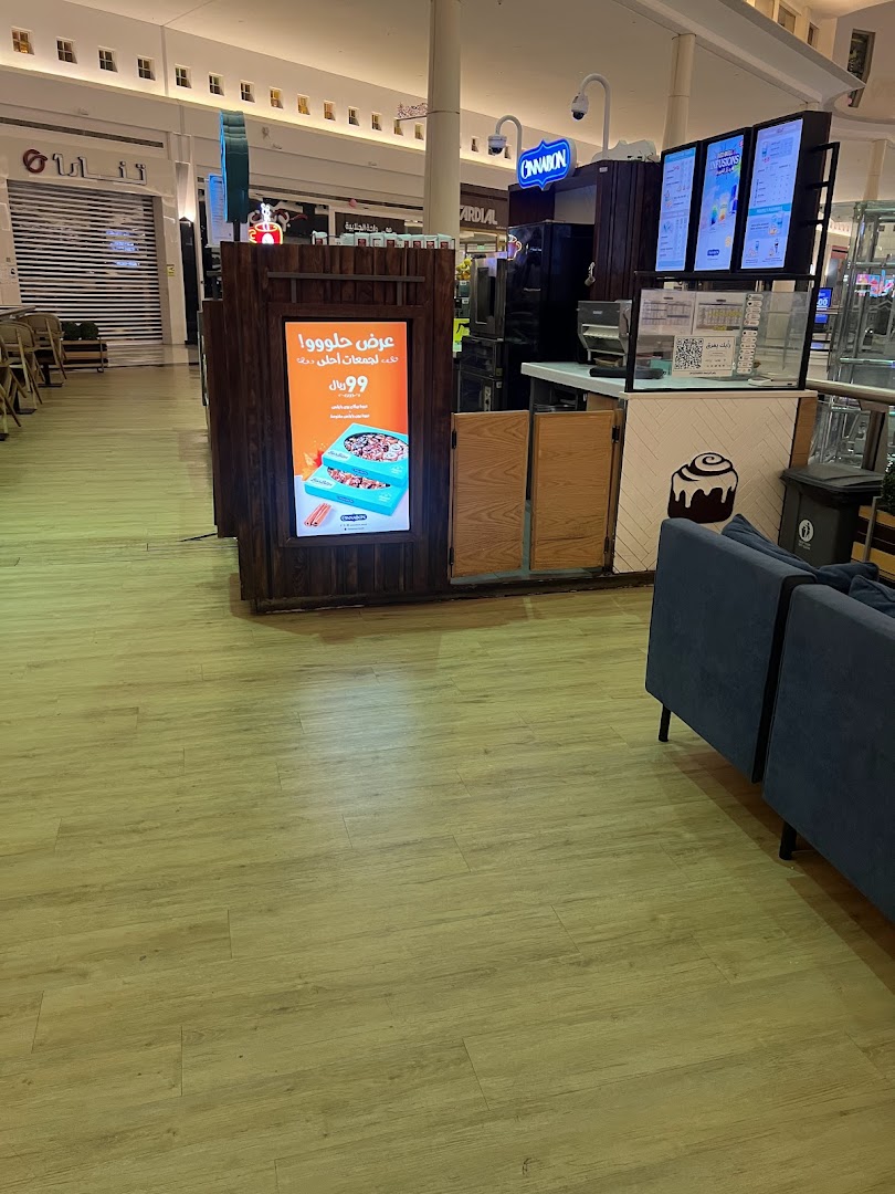 A Cinnabon and Seattle's Best Coffee kiosk in a mall with seating.