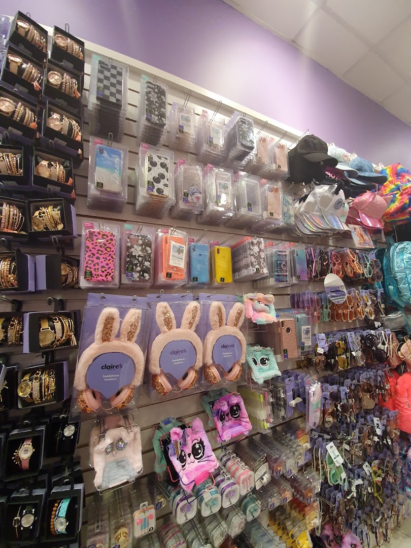 A wall display in Claire's featuring watches, phone cases, headphones, and accessories.