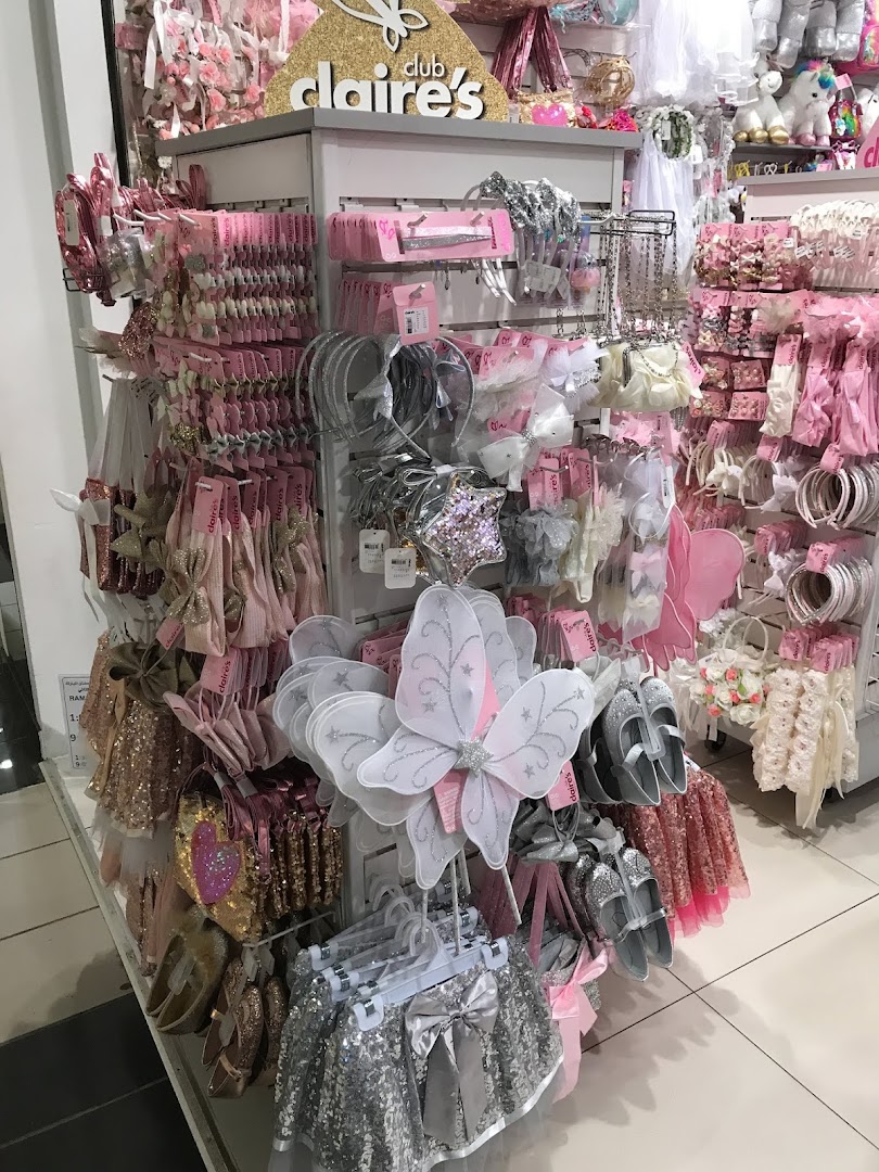 A Claire's store display filled with sparkly accessories, hair clips, and fairy wings.