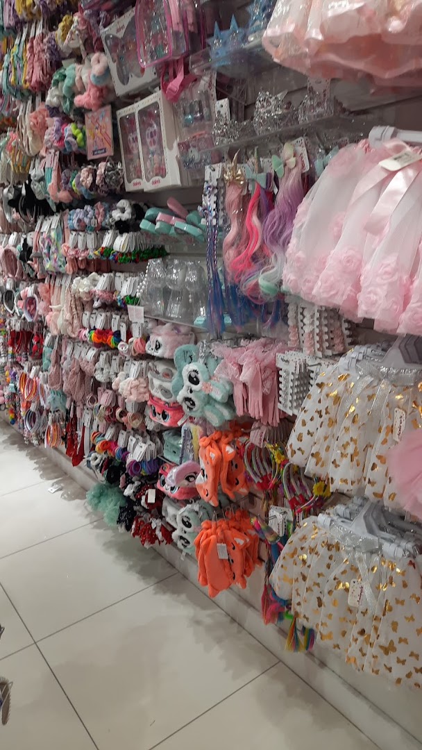 A wall display filled with colorful hair accessories, plush toys, and sparkly crowns.